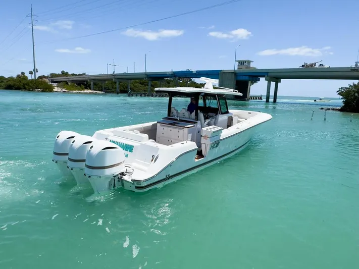 Aquamarine Yacht Photos Pics 2019 HCB 39 Speciale boat cruising in turquoise waters near a bridge.