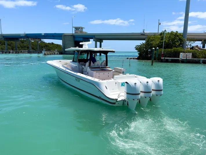 Aquamarine Yacht Photos Pics 2019 HCB 39 Speciale boat cruising in turquoise waters near a bridge.