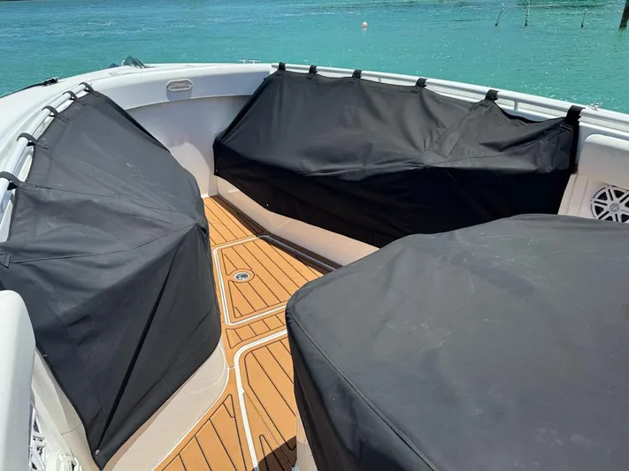 Aquamarine Yacht Photos Pics 2019 HCB 39 Speciale boat interior with covered seating, teak flooring, and turquoise water backdrop.