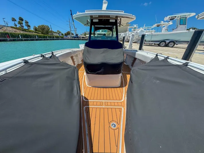 Aquamarine Yacht Photos Pics 2019 HCB 39 Speciale boat with teak deck, docked by turquoise water.