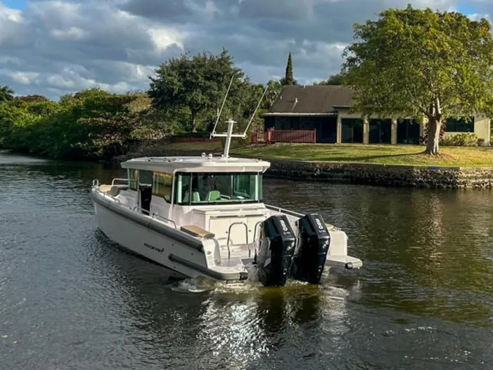  Yacht Photos Pics 2024 Axopar 37XC CROSS CABIN boat cruising on a scenic river.