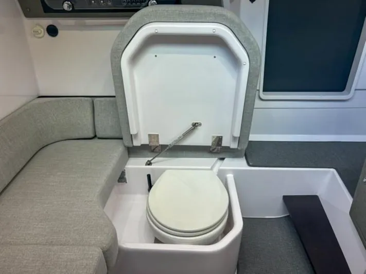  Yacht Photos Pics 2024 Axopar 37XC CROSS CABIN interior with compact marine toilet and seating area.
