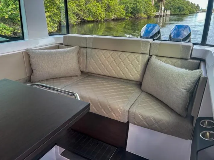  Yacht Photos Pics Luxurious seating in 2024 Axopar 37XC CROSS CABIN, featuring elegant cushions and scenic water view.