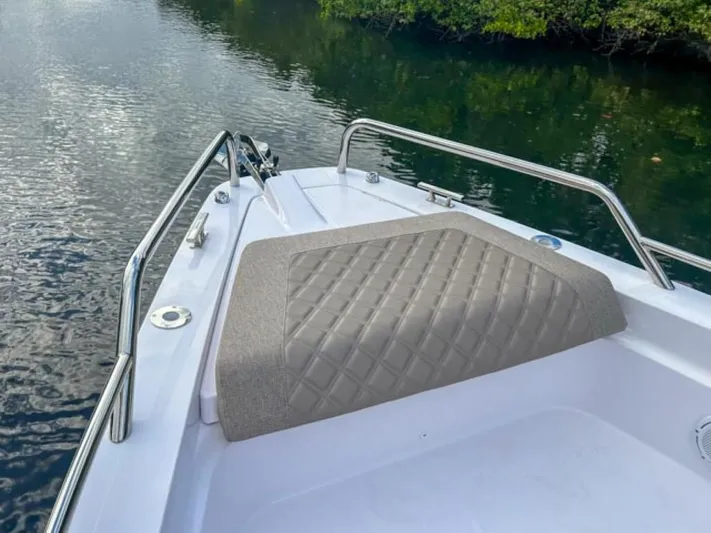  Yacht Photos Pics 2024 Axopar 37XC CROSS CABIN bow with cushioned seating on calm water.