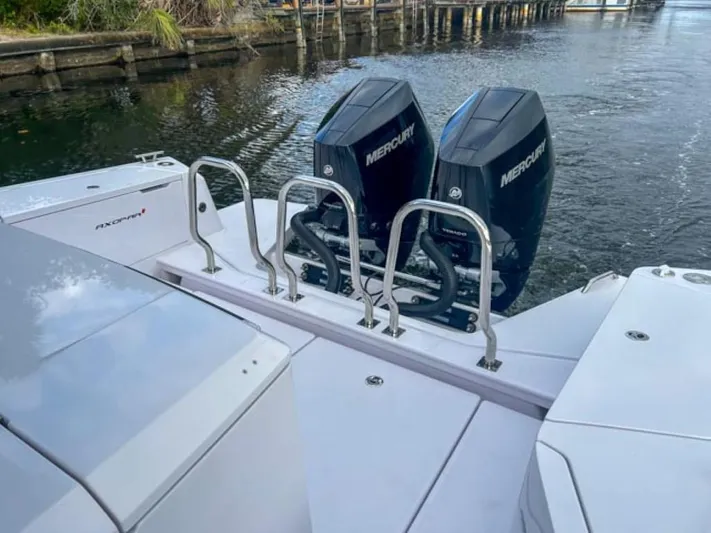  Yacht Photos Pics 2024 Axopar 37XC CROSS CABIN with dual Mercury outboard engines on a calm waterway.