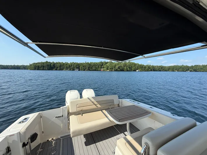  Yacht Photos Pics 2019 Boston Whaler 320 Vantage on serene lake with canopy and seating area.