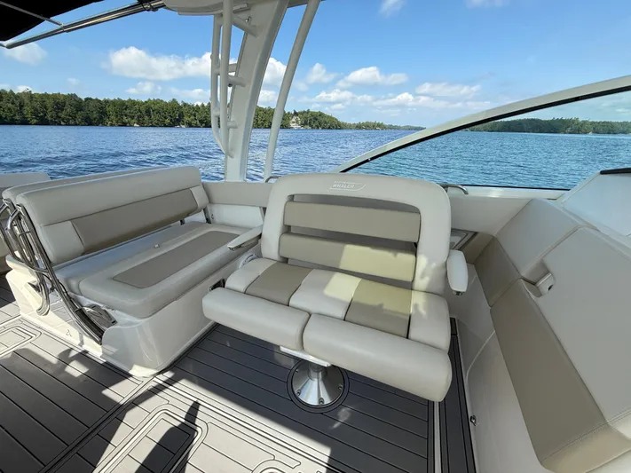  Yacht Photos Pics 2019 Boston Whaler 320 Vantage interior with comfortable seating, overlooking serene lake and forest.