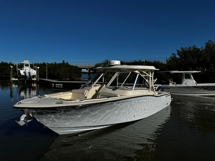 None Yacht Photos Pics 2022 Grady-White Freedom 325 boat docked on calm water under clear blue sky.