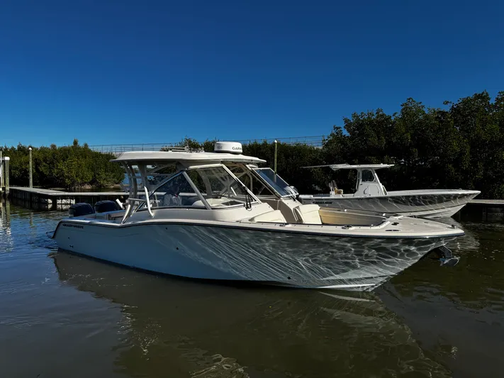 None Yacht Photos Pics 2022 Grady-White Freedom 325 boat docked on calm water under clear blue sky.