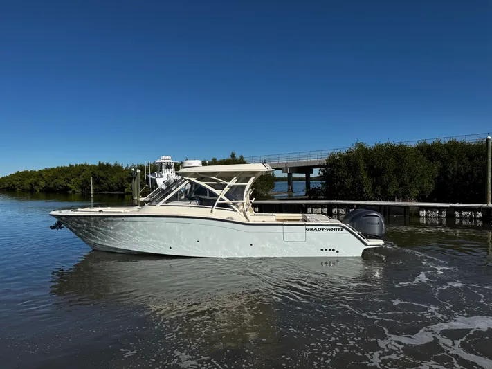 None Yacht Photos Pics 2022 Grady-White Freedom 325 boat on calm water, clear blue sky background.