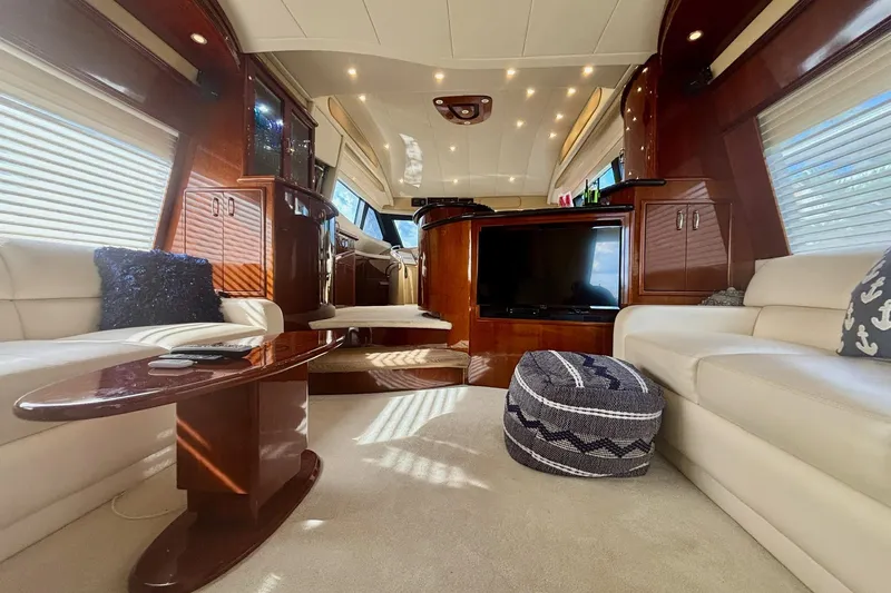  Yacht Photos Pics Luxurious interior of a 2004 Marquis 59 yacht with elegant wood finishes and plush seating.
