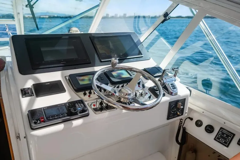 Gyro Stabilized Yacht Photos Pics Helm of 2005 Cabo 35 Express boat with modern navigation equipment and steering wheel.