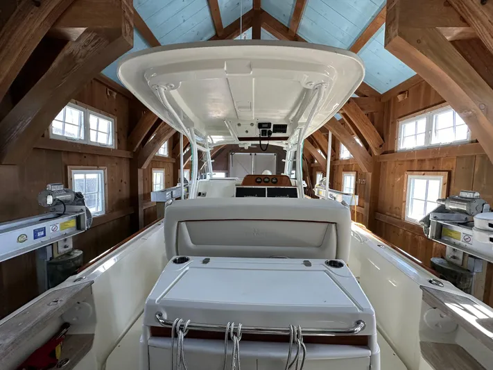 Heron Yacht Photos Pics 2017 Hunt Yachts 32 Center Console in wooden boathouse, showcasing sleek design and spacious interior.