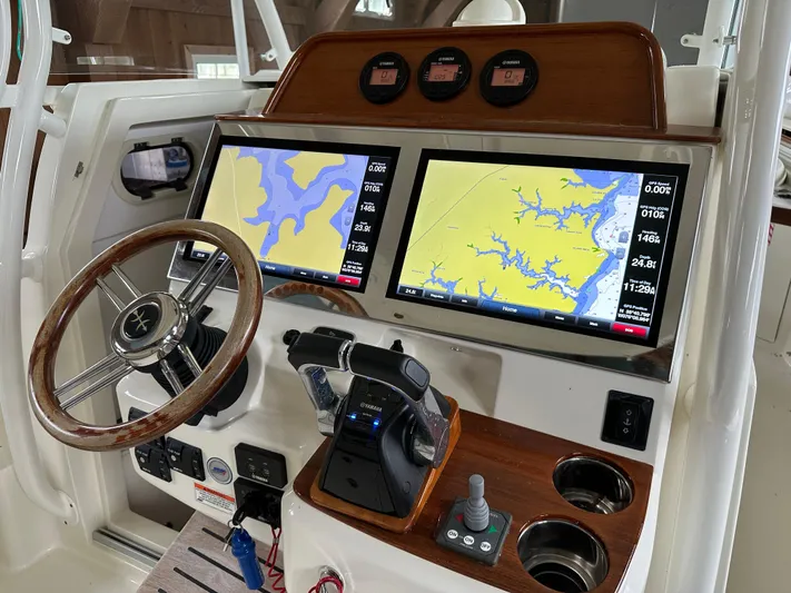 Heron Yacht Photos Pics 2017 Hunt Yachts 32 Center Console dashboard with dual navigation screens and wooden steering wheel.