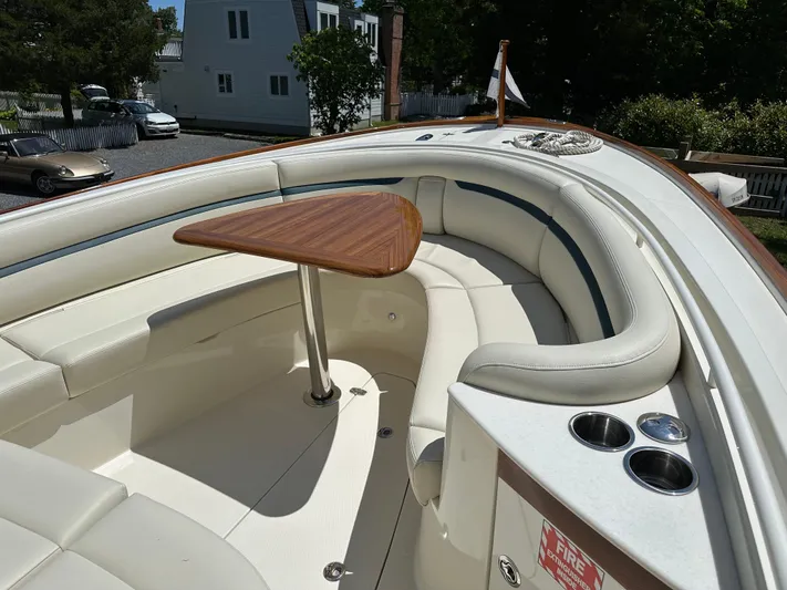 Heron Yacht Photos Pics 2017 Hunt Yachts 32 Center Console with cushioned seating and wooden table in the bow area.