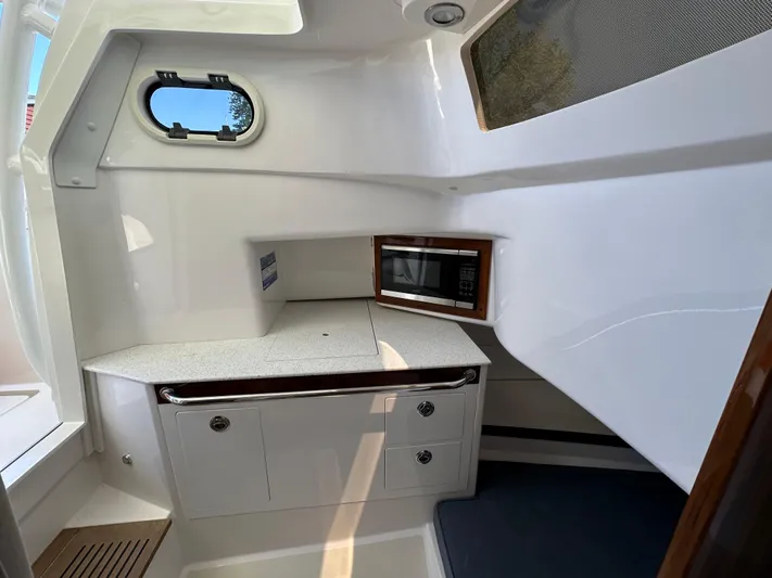 Heron Yacht Photos Pics 2017 Hunt Yachts 32 Center Console interior with kitchenette and porthole window.