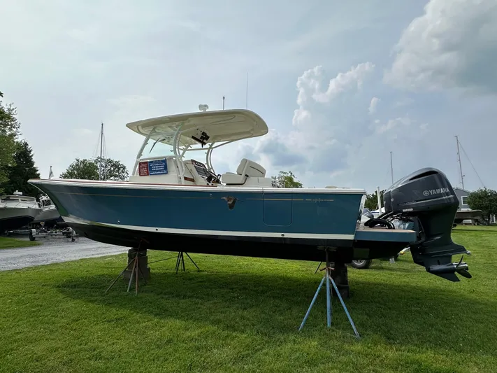 Heron Yacht Photos Pics 2017 Hunt Yachts 32 Center Console on display, blue hull, outboard motor, grassy setting.