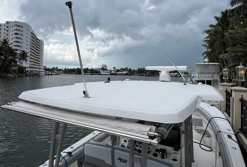 The Perfect Predator Yacht Photos Pics 2017 Mako 414 CC Bluewater boat docked by waterfront buildings under cloudy sky.