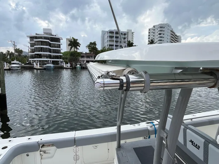 The Perfect Predator Yacht Photos Pics 2017 Mako 414 CC Bluewater boat docked near waterfront buildings under cloudy sky.