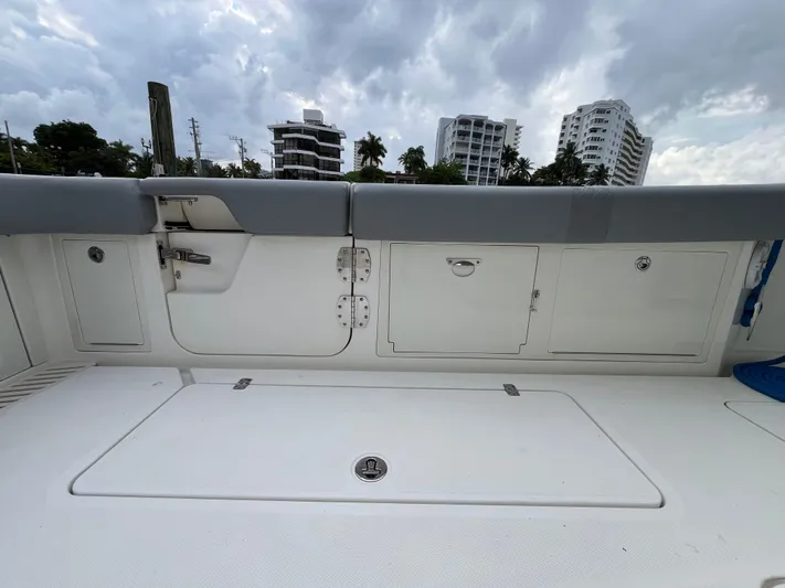 The Perfect Predator Yacht Photos Pics 2017 Mako 414 CC Bluewater boat deck with storage compartments, cloudy sky background.