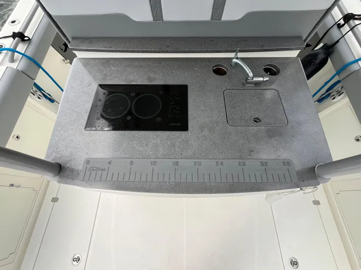 The Perfect Predator Yacht Photos Pics 2017 Mako 414 CC Bluewater boat kitchen with sink, stove, and measuring ruler.