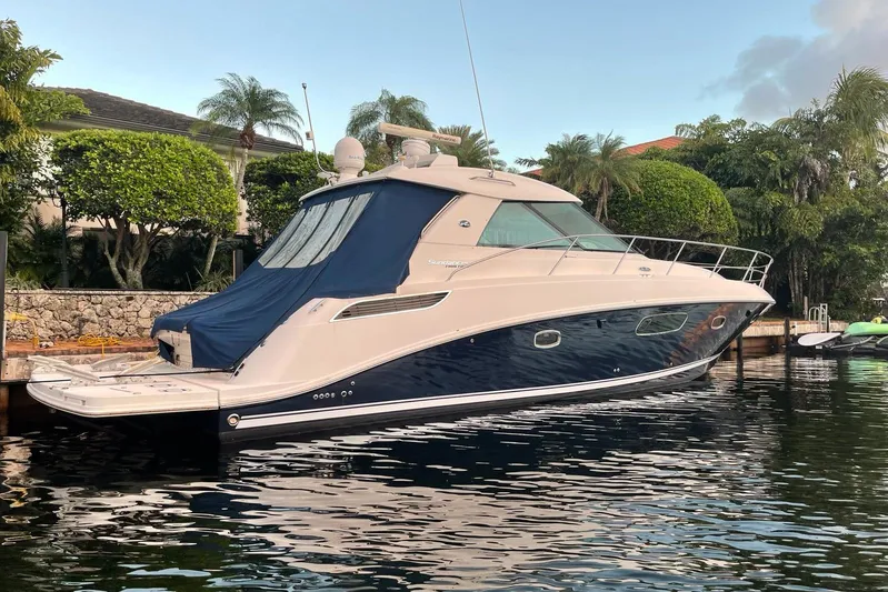 Beach House Yacht Photos Pics 2010 Sea Ray 450 Sundancer yacht docked by lush greenery.