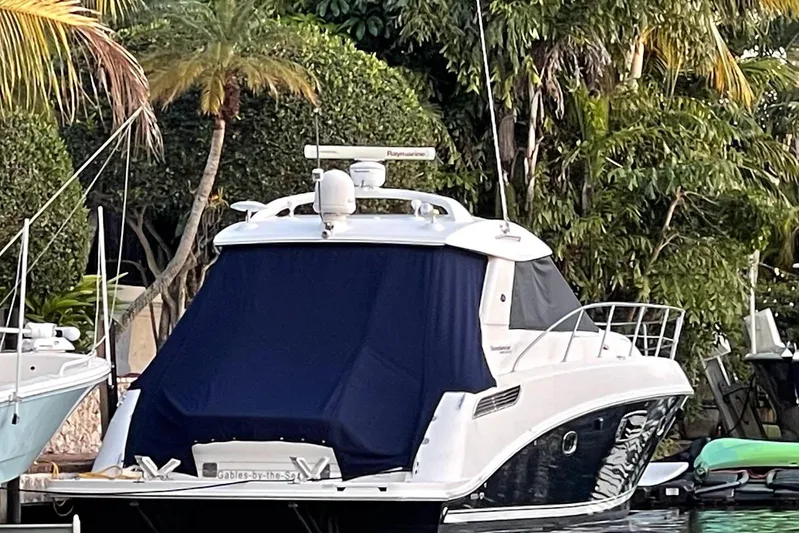 Beach House Yacht Photos Pics 2010 Sea Ray 450 Sundancer yacht docked, surrounded by lush greenery.