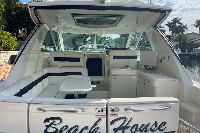 Beach House Yacht Photos Pics 2010 Sea Ray 450 Sundancer yacht interior with seating and kitchenette, docked by waterfront.