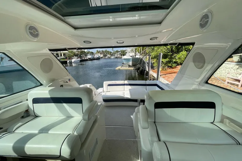 Beach House Yacht Photos Pics Interior view of 2010 Sea Ray 450 Sundancer yacht with luxurious seating and waterfront backdrop.