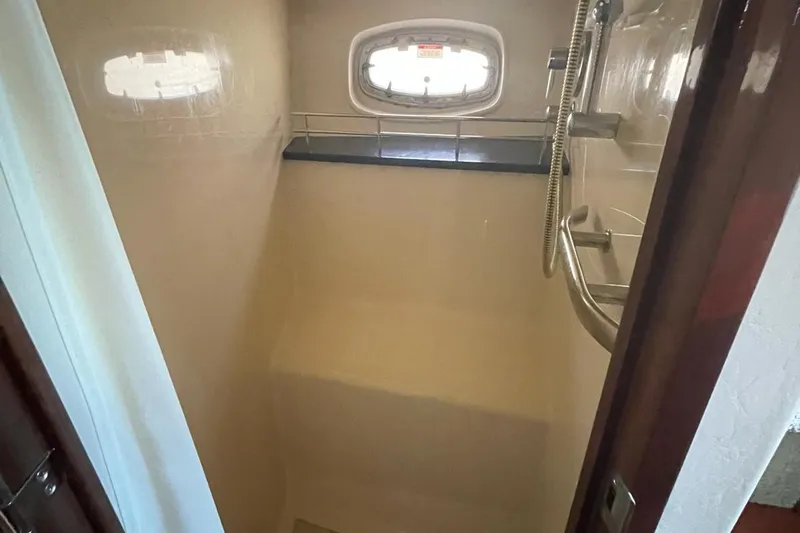 Beach House Yacht Photos Pics Shower area inside 2010 Sea Ray 450 Sundancer yacht, featuring a window and handheld showerhead.