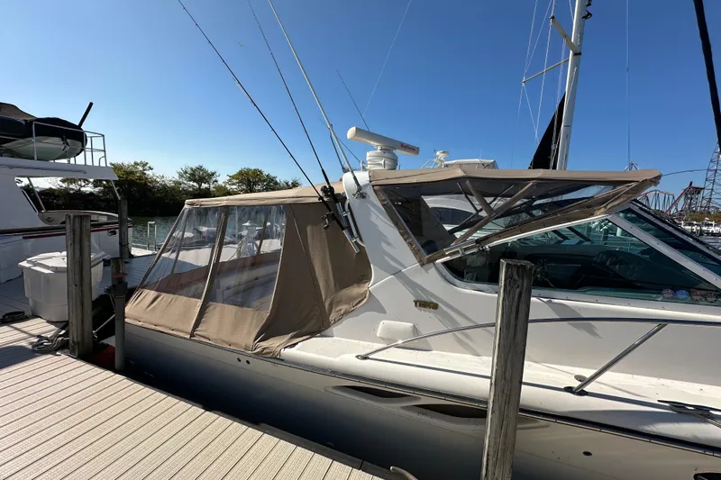  Yacht Photos Pics 2001 Tiara Yachts 3500 Open docked, featuring a beige canopy and sleek design.