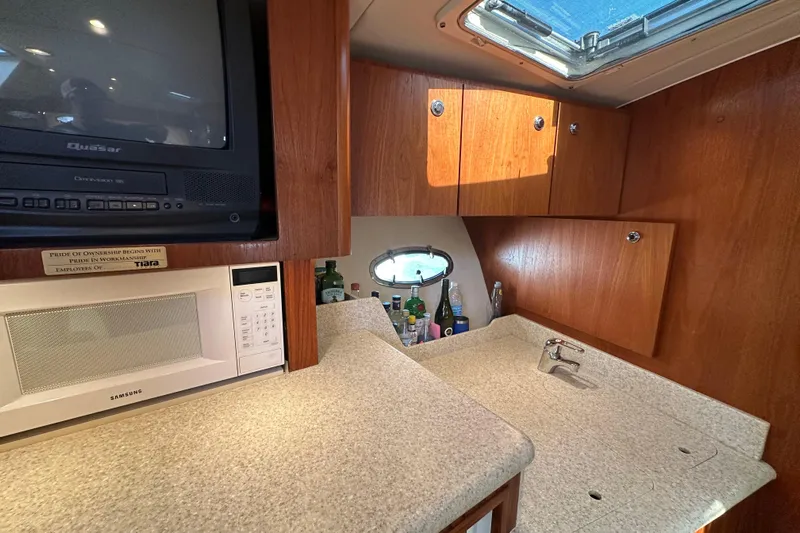  Yacht Photos Pics 2001 Tiara Yachts 3500 Open interior with kitchenette, TV, and storage cabinets.
