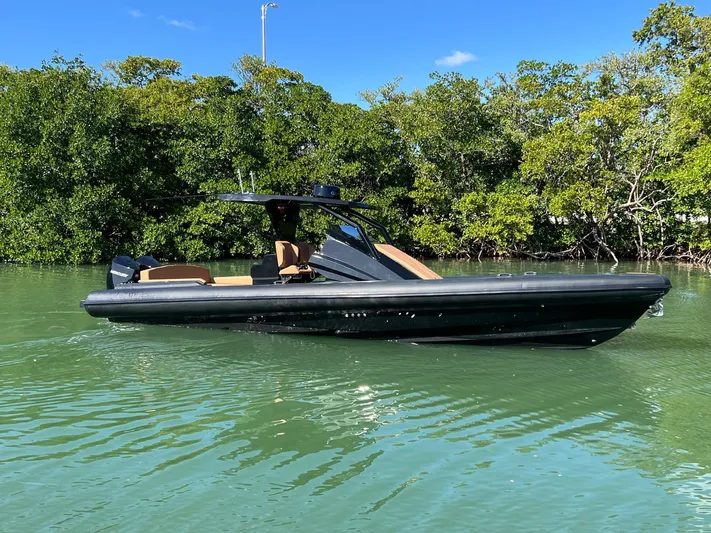 Novielli Yacht Photos Pics 2026 Novielli Veloche 349 boat on calm water, surrounded by lush greenery.