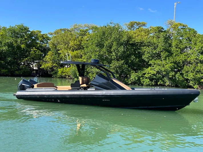 Novielli Yacht Photos Pics Sleek 2026 Novielli Veloche 349 boat on calm water, surrounded by lush greenery.