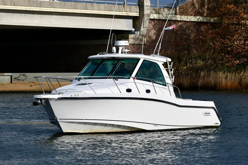  Yacht Photos Pics 2011 Boston Whaler 345 Conquest boat cruising on a calm river near a bridge.