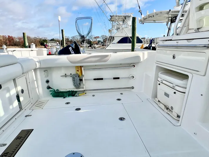  Yacht Photos Pics 2011 Boston Whaler 345 Conquest boat deck with fishing gear and storage compartments.