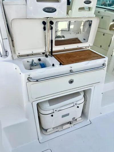  Yacht Photos Pics 2011 Boston Whaler 345 Conquest boat galley with sink, cutting board, and storage.