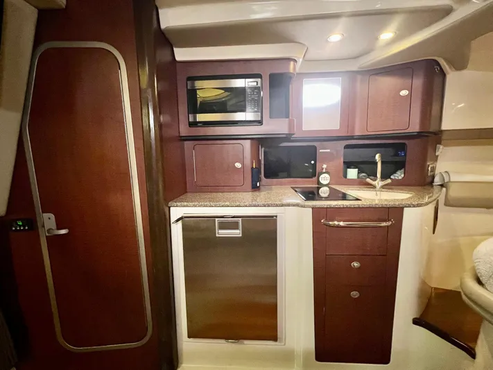  Yacht Photos Pics 2011 Boston Whaler 345 Conquest interior kitchen with microwave, sink, and cabinetry.