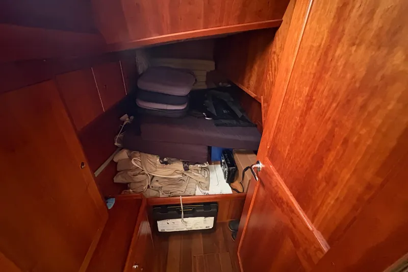 Lino Yacht Photos Pics Interior storage space of 2019 Chatam Extreme 42 yacht with wooden finish and stacked items.