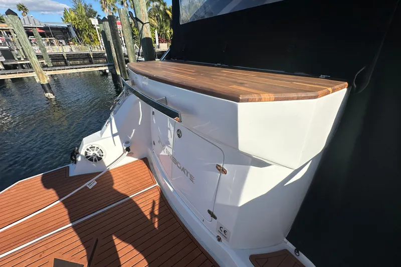  Yacht Photos Pics 2025 NX Boats 370, rear deck view with wooden surface, docked by the water.