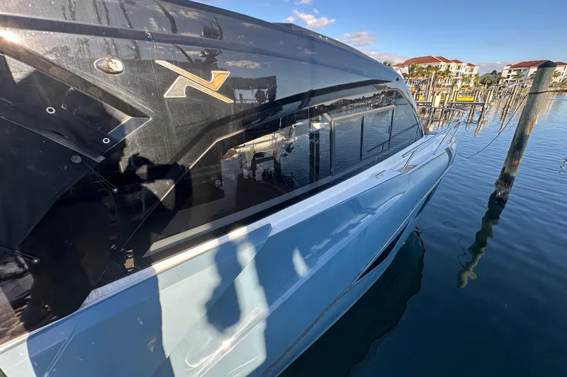  Yacht Photos Pics 2025 NX Boats 370 docked, reflecting on calm water with clear blue sky.
