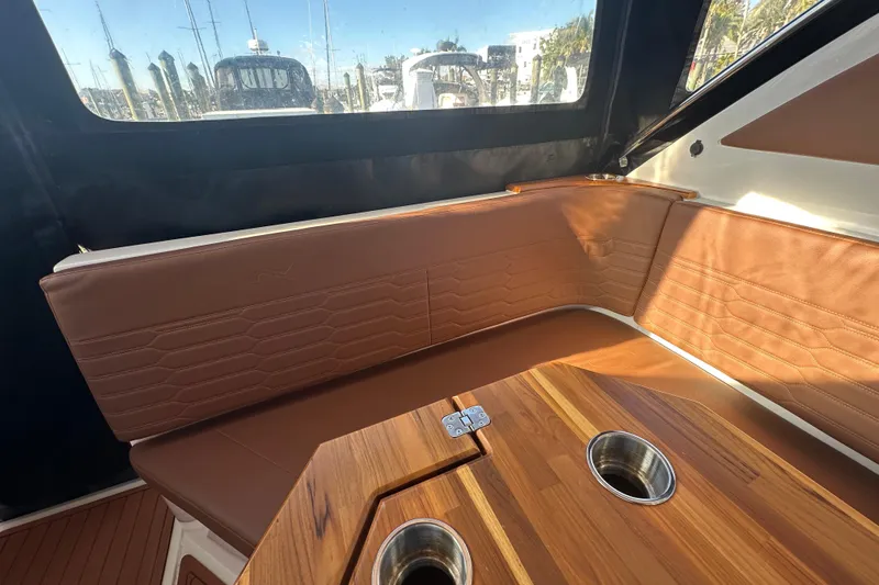  Yacht Photos Pics Interior of 2025 NX Boats 370 with brown leather seating and wooden table.