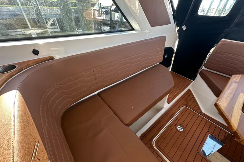  Yacht Photos Pics 2025 NX Boats 370 interior with brown leather seating and wooden flooring.
