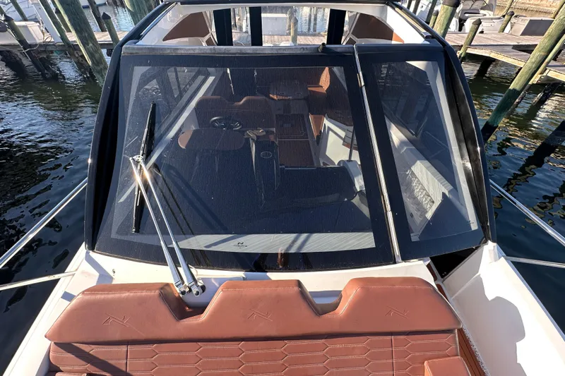  Yacht Photos Pics 2025 NX Boats 370 with sleek windshield and luxurious interior, docked at a marina.