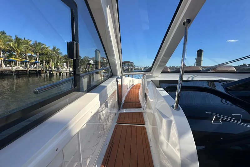  Yacht Photos Pics 2025 NX Boats 370 yacht with sleek design, docked by palm trees and clear blue sky.