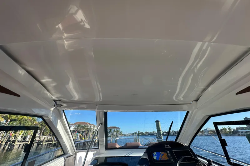  Yacht Photos Pics Interior view of 2025 NX Boats 370, showcasing helm and waterfront scenery.