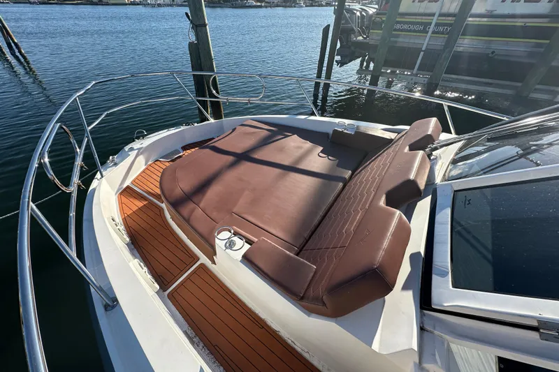  Yacht Photos Pics 2025 NX Boats 370 with brown sunbed on deck, docked by the water.