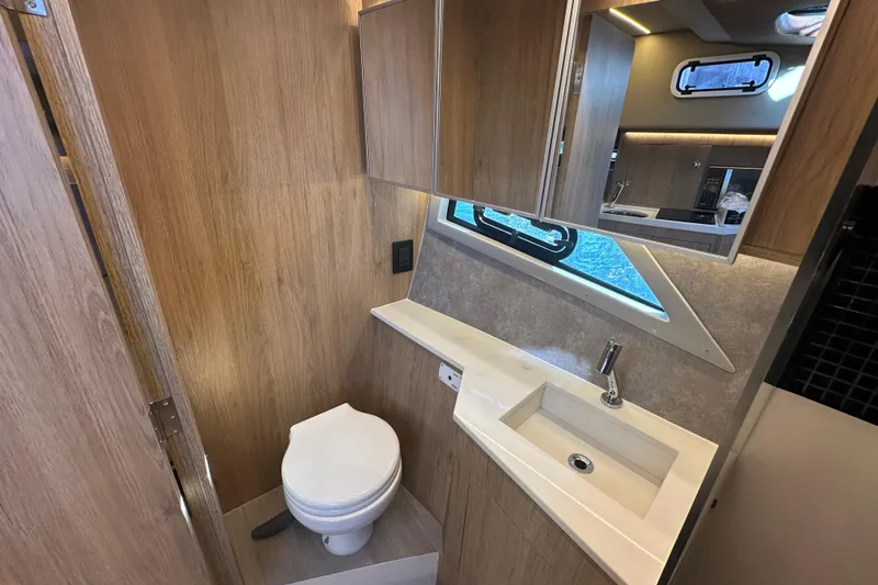  Yacht Photos Pics Modern bathroom interior on 2025 NX Boats 370, featuring wood paneling and sleek fixtures.