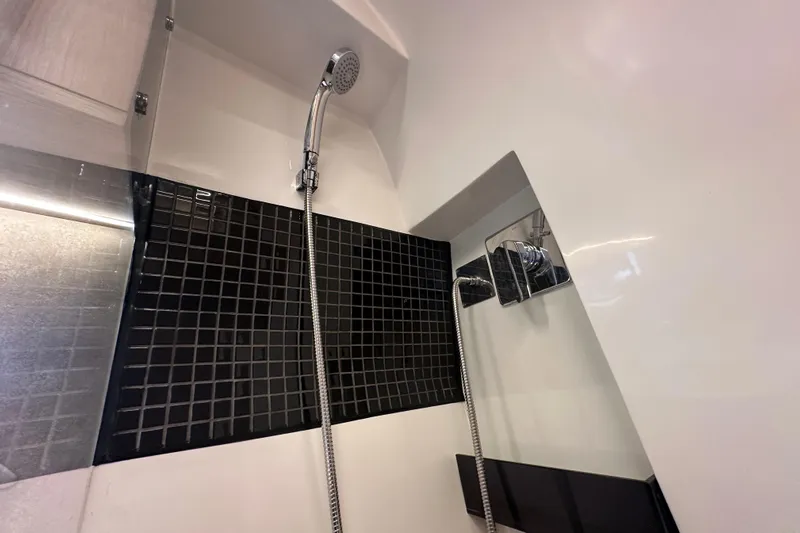  Yacht Photos Pics Shower area in 2025 NX Boats 370, featuring modern black tile and chrome fixtures.