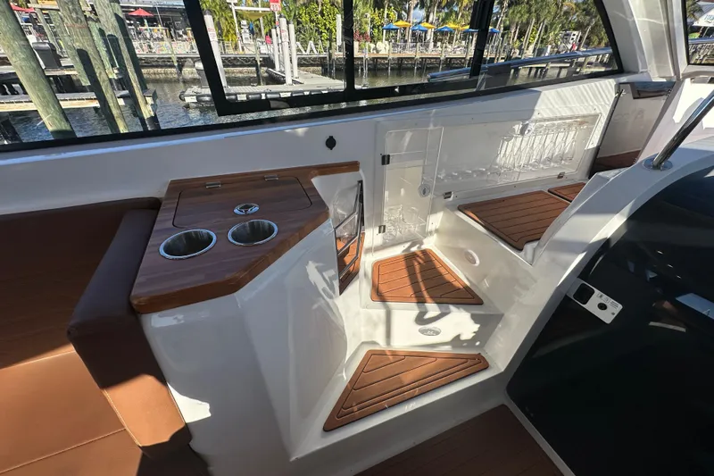  Yacht Photos Pics 2025 NX Boats 370 interior with wooden accents and cup holders, dockside view.